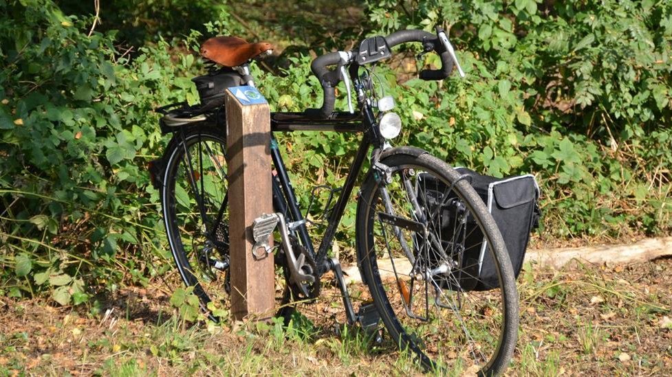 Fahrrad angelehnt an Hinweis Erlebnispfad Holter Wald